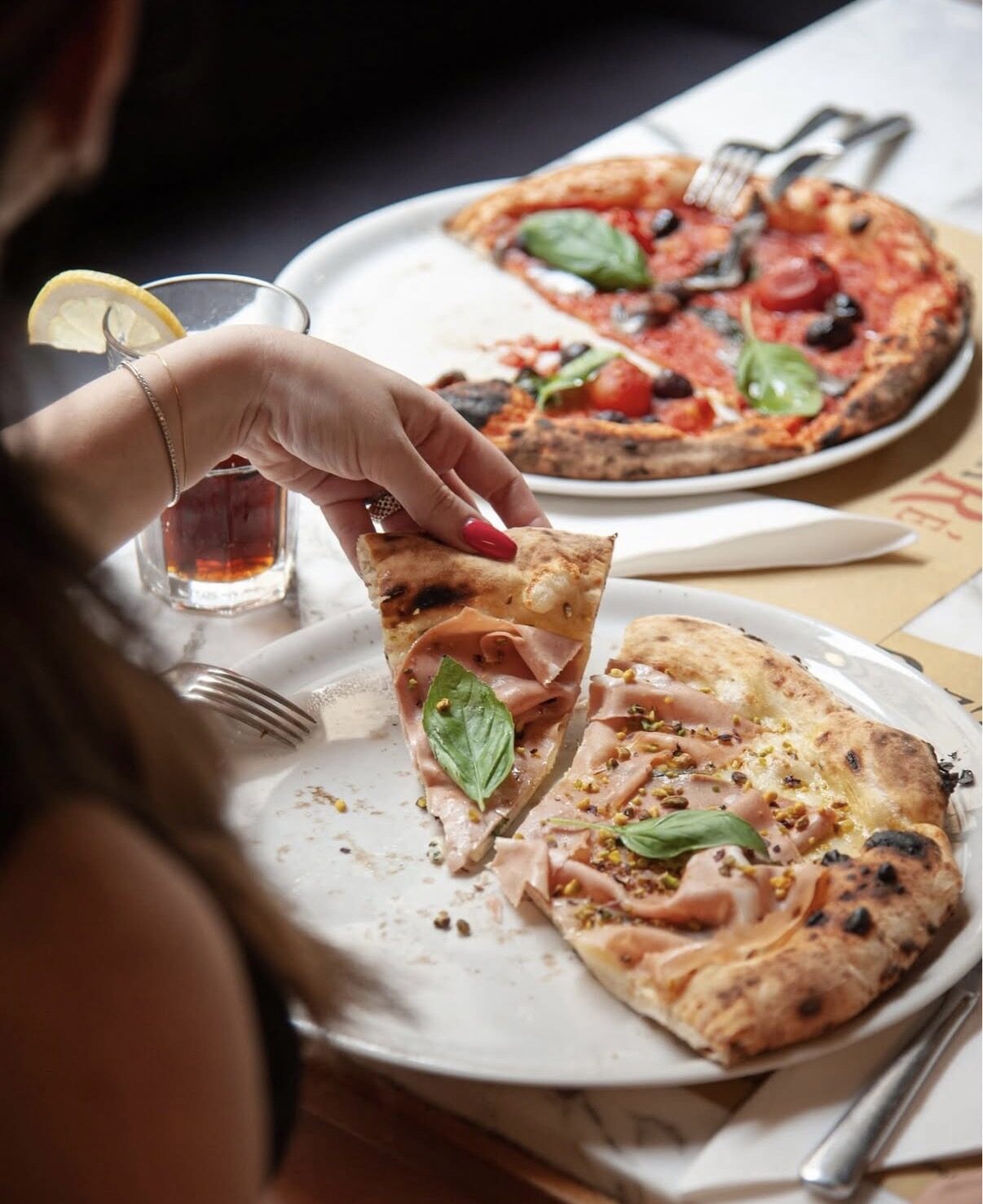 Pizza con mortadella e granella di pistacchi servita in sala