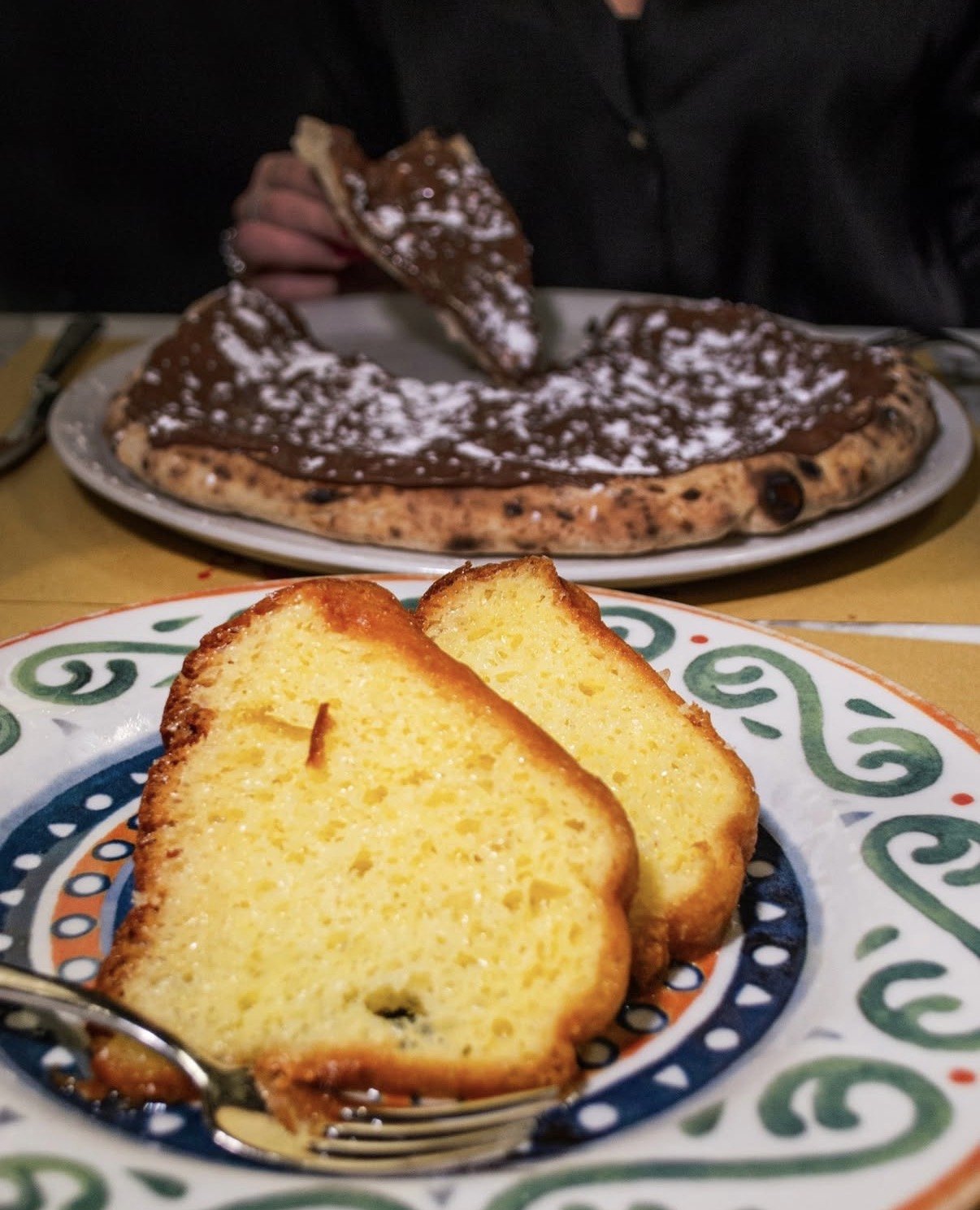 Pizza dolce al cioccolato con zucchero a velo e fette di ciambellone
