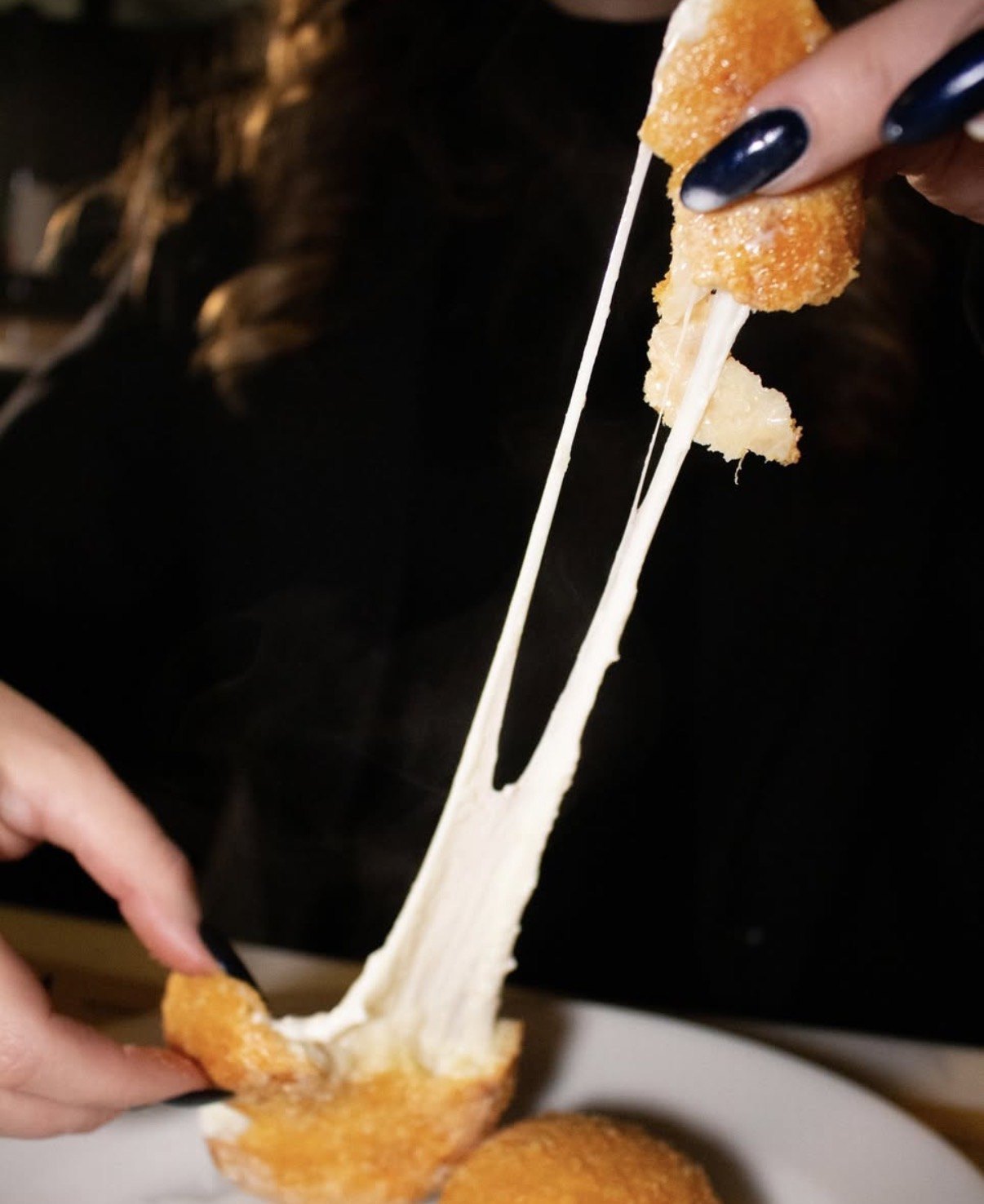 Supplì spezzato a metà con la mozzarella filante